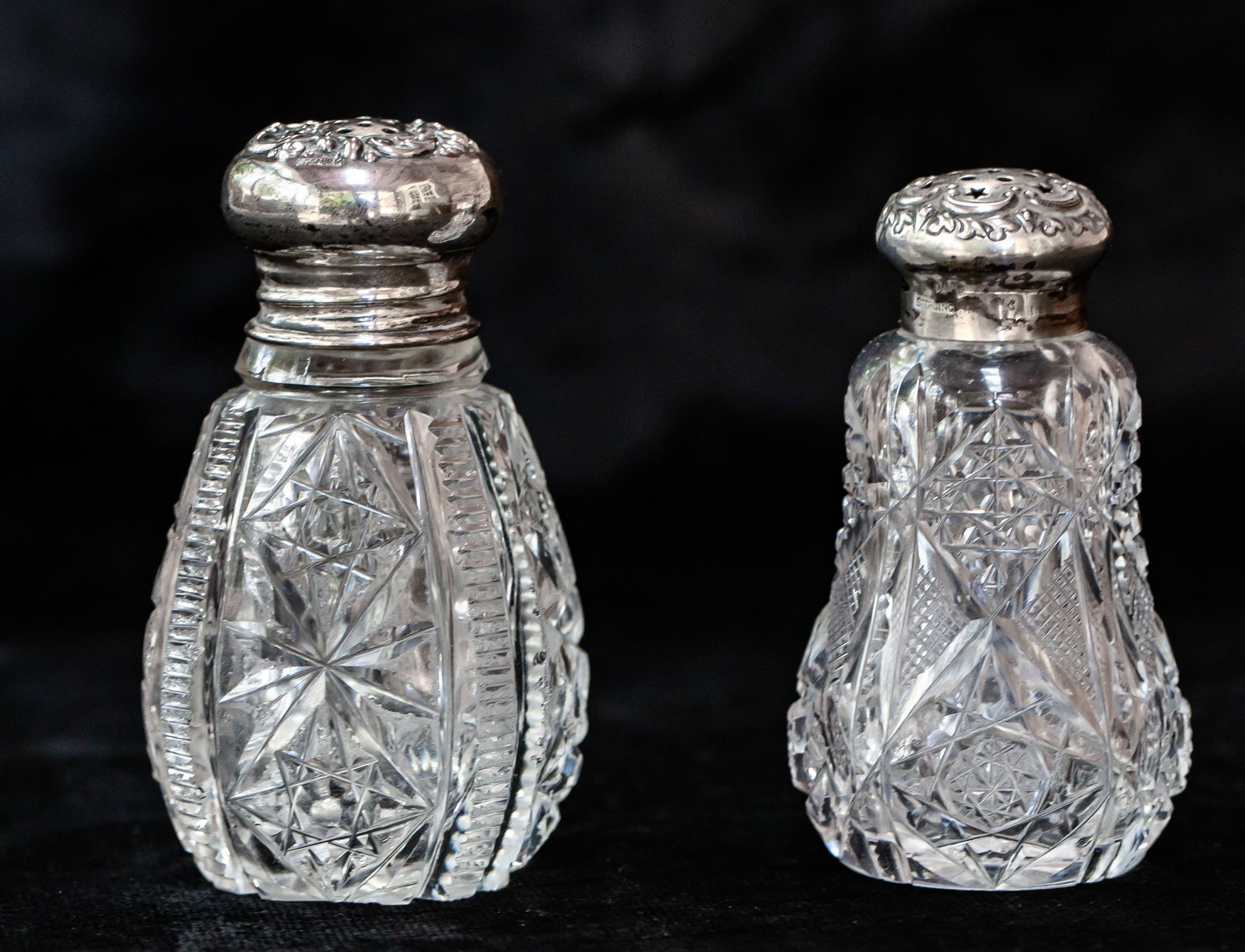 Two Hawkes Meriden American Brilliant Cut Glass Salt Shakers w/ Sterling Silver Tops: Two salt shakers - one signed Hawkes and one by Meriden w/ Wilcox sterling top