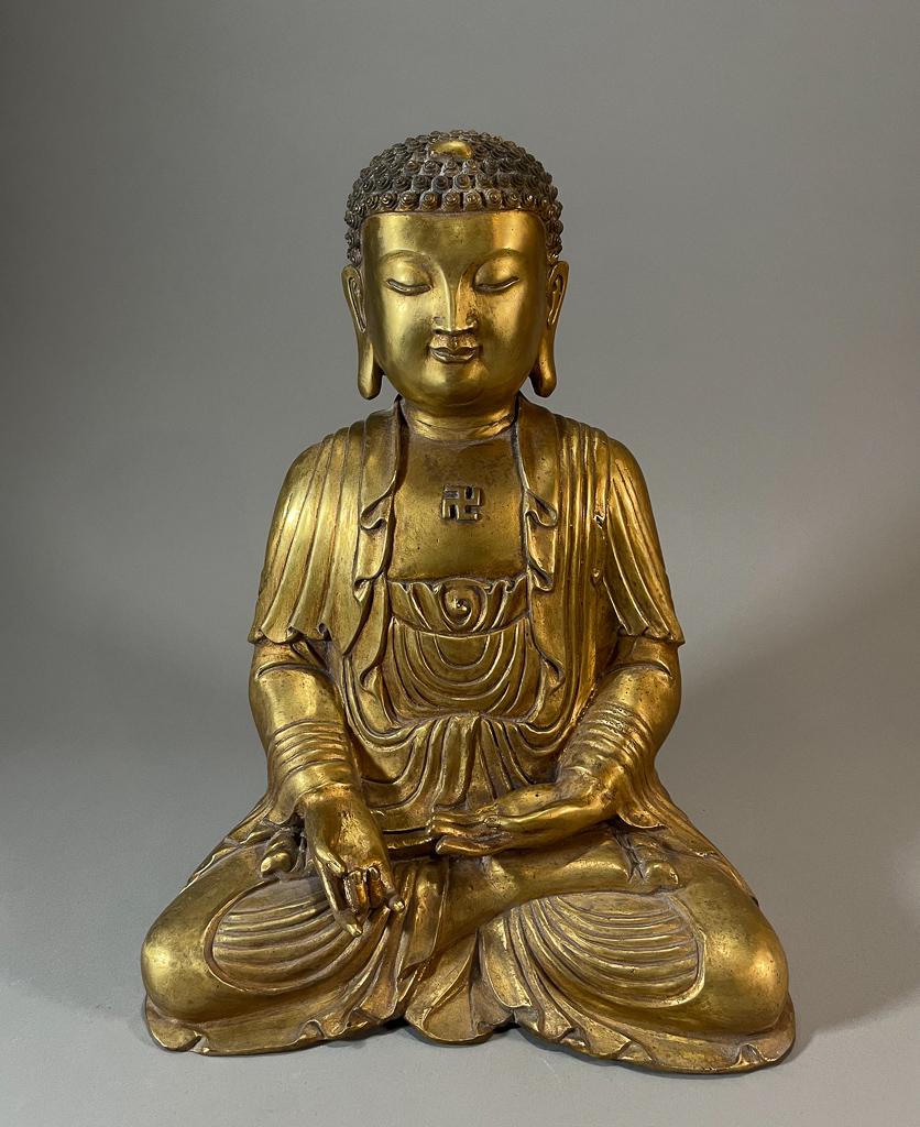Chinese Gilt Bronze Seated Buddha: Chinese gilt bronze seated Buddha; hands in Varada Mudra, with Buddhist swastika to chest; H: 16" (approx.)