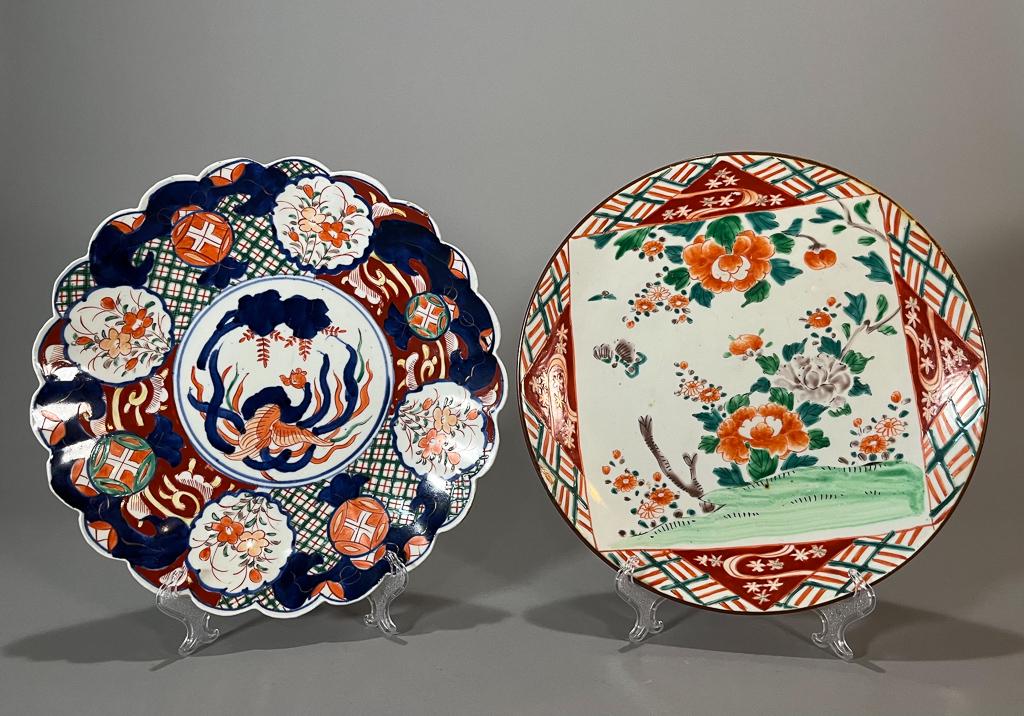 Two Japanese Imari Porcelain Chargers: Two old or antique Japanese Imari porcelain chargers, each with floral design; one with central foliate medallion with scalloped rim, decorative blue design underneath and circles to base, the other w
