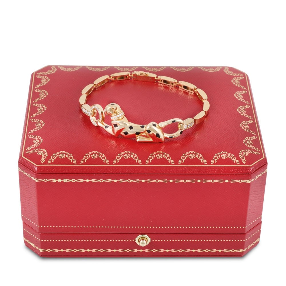 18KT GOLD PANTHÈRE BRACELET SET WITH DIAMONDS, ONYX AND EMERALD, BY CARTIER: Total weight gr. 22,8 Length approx. 17 cm Signed Cartier Numbered XQX262 Accompanied by the original case and box