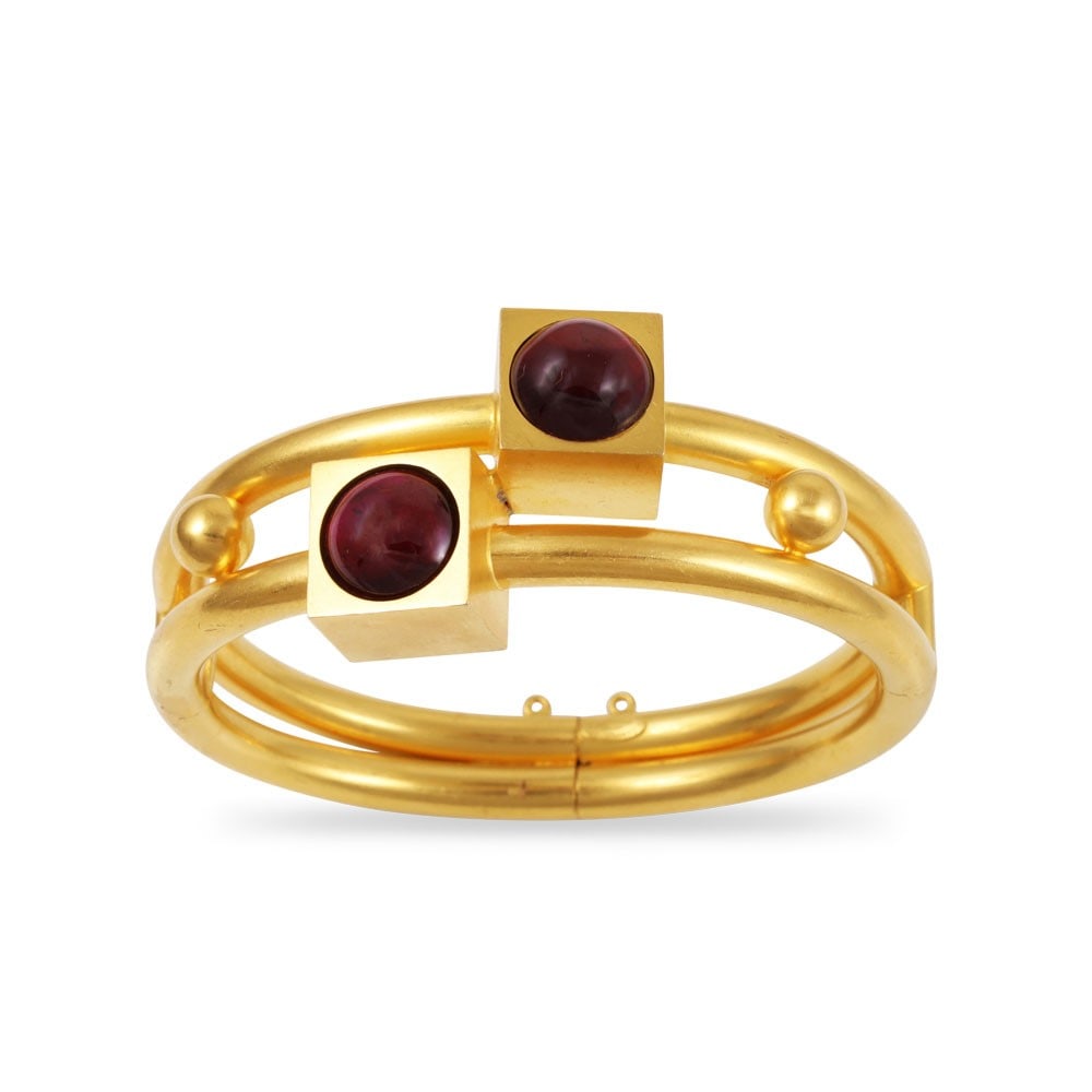 HIGHT-CARAT GOLD BANGLE SET WITH GARNETS: Total weight gr. 36,3 Size approx. 16 cm Signed G. Confalonieri F. Milano