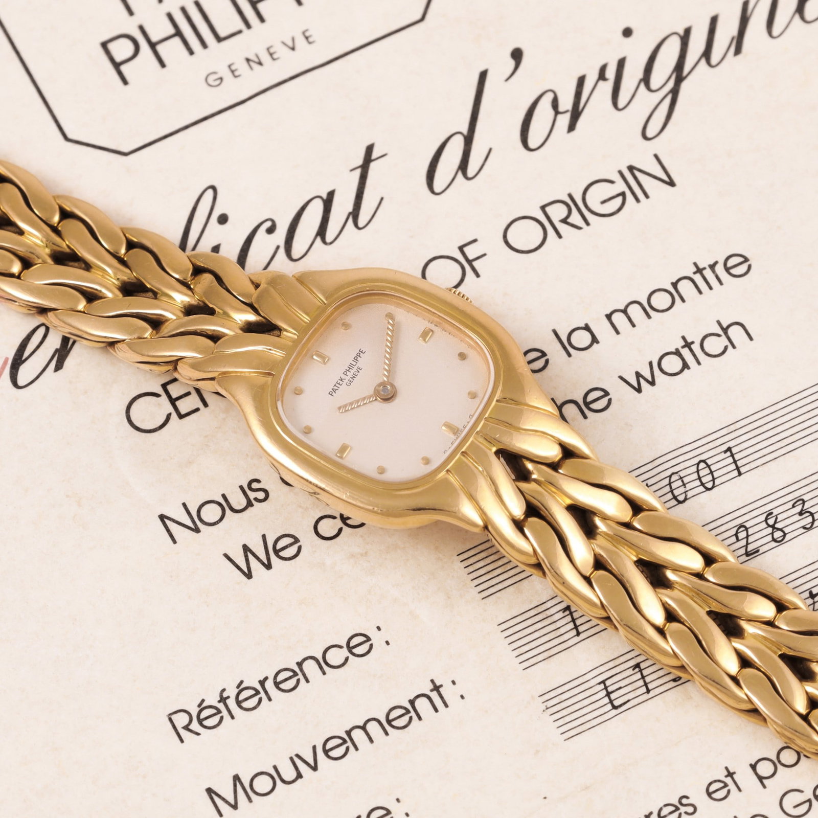 PATEK PHILIPPE: PATEK PHILIPPE Ref: 4715, 'La Flamme' Very fine and elegant, cushion-shaped, 18K yellow gold lady's quartz wristwatch with an integrated twisted 18K yellow gold Patek Philippe bracelet with deployant