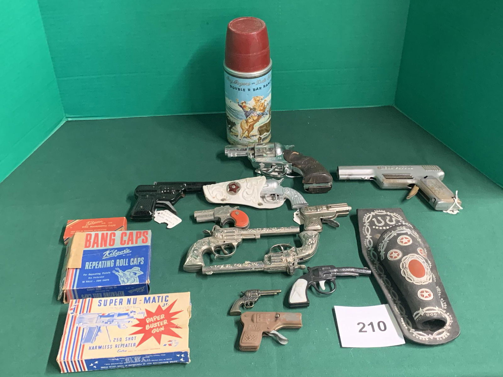 Misc. Western pistols, caps, Roy Rogers thermos: Rubber holster, Super Nu-Matic Pistol, Bubble Coral Danger, Pair of Star die cast pistols. Shipping is available.