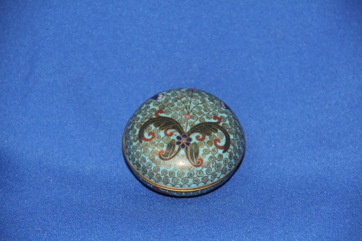 Round Lidded Cloisonne Box: Round lidded cloisonne box. Light blue background, floral design and dark blue interior. 3 inches diameter and 1 1/4 inches tall.