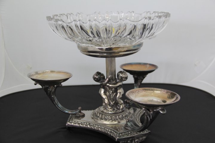 Silverplate Three Arm Epergne: Silverplate 3 arm epergne with cherubs and a clear glass center bowl. Measures 12 x 15 inches. Center bowl is 11 1/2 inches in diameter. Some tarnish.