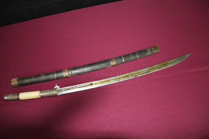 Curved Hollowed 22 1/2 in. Blade: 196-879 Curved hollowed 22 1/2 in. blade with elongated point. Blade has inscription on blackened medial. Grip covered in silver alloy with gilt finish. Old wood scabbard with silver bands.