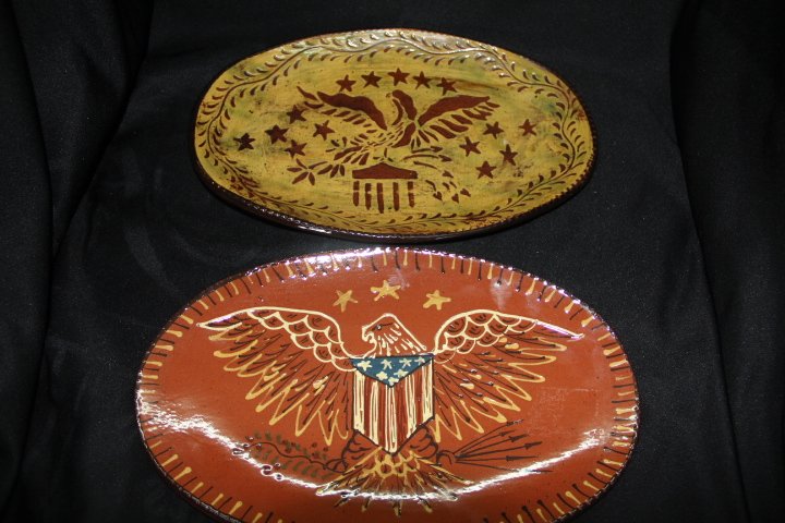 Pair of Redware Trays by Cazan: 14-1702 Pair of Redware trays by Cazan. Both have an American Eagle design. The red, white and blue tray is from 2004, signed Ginger Cazan. The yellow and red tray is from 2001, signed Ginger Cazan an