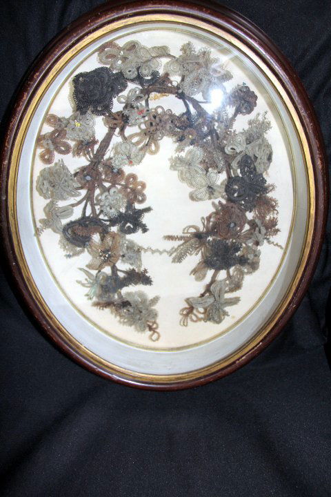 Vintage Hair Wreath in Shadow Box Frame: 18-1195 Vintage hair wreath in oval shadow box frame. Various shades of blonde, auburn, light and dark brown. Wreath is in a U-shape with a variety of beads woven in the flowers. Frame has various scr