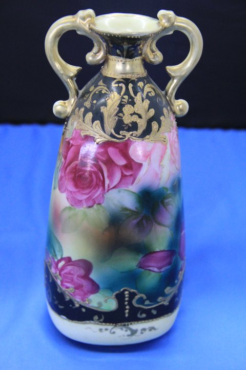 Nippon Vase: 108-6057 Nippon double handled vase. Hand painted roses and gilt decoration. No mark. Measures 8 1/2 in. tall and 3 1/4 at the base.