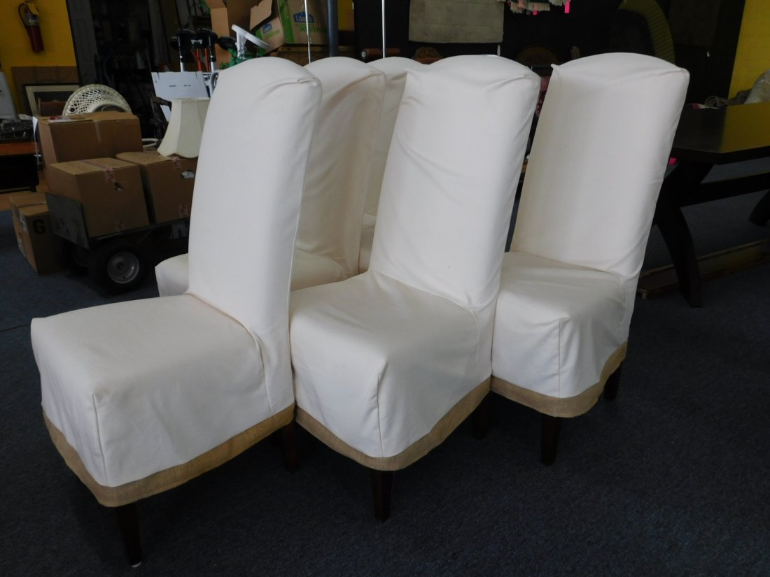 Set of Six Ballard Design Dining Room Chairs: Set of 6 off white dining room chairs with slipcovers by Ballard Design. Slipcovers are off white with a burlap fabric trim. Each measures 44 inches taoo and 21 inches wide.