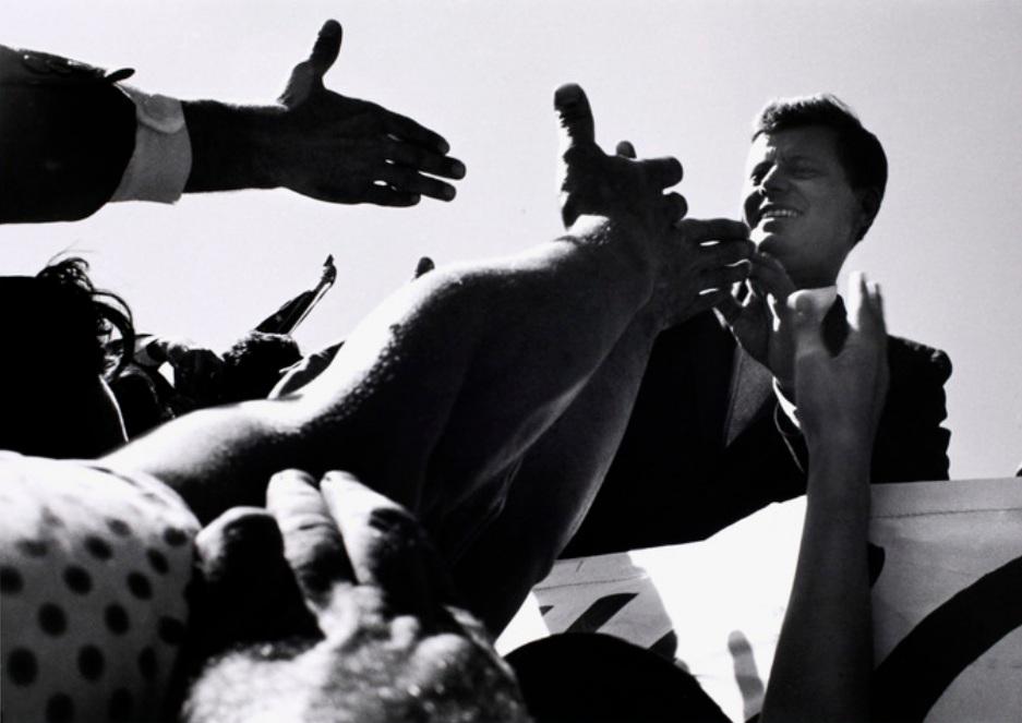 CORNELL CAPA John F. Kennedy Shaking Hands with: CAPA CORNELLBudapest (Ungheria) 1918John F. Kennedy Shaking Hands with Supporters, Mic2021Stampa Digitale su Carta Museale/Digital Print on Museum Paper15,20x15,20Certificato di autenticitÃ Firmata