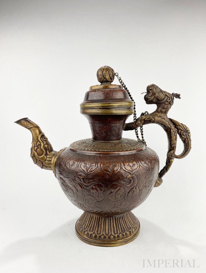 A TIBETAN COPPER KETTLE: A TIBETAN COPPER KETTLE, modern era. The kettle is finely formed of hand-beaten copper, the handle is well cast in the form of a mythical creature and spout emerging from the Makara's mouth. H.31.5cm.