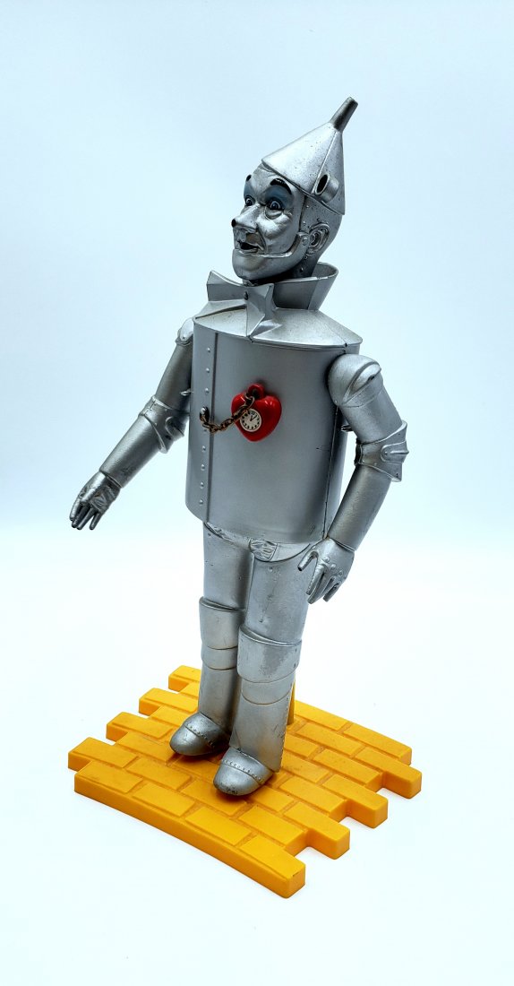 Vintage Tin Man Figurine on Yellow Brick Road: Wizard of Oz Tin Man wearing his awarded heart clock with Yellow Brick Road doll stand. Plastic figurine collectable by Presents/Hamilton Gifts. DIMENSIONS: 15.5" high, 8" wide, 6" deep. ORIGIN: China