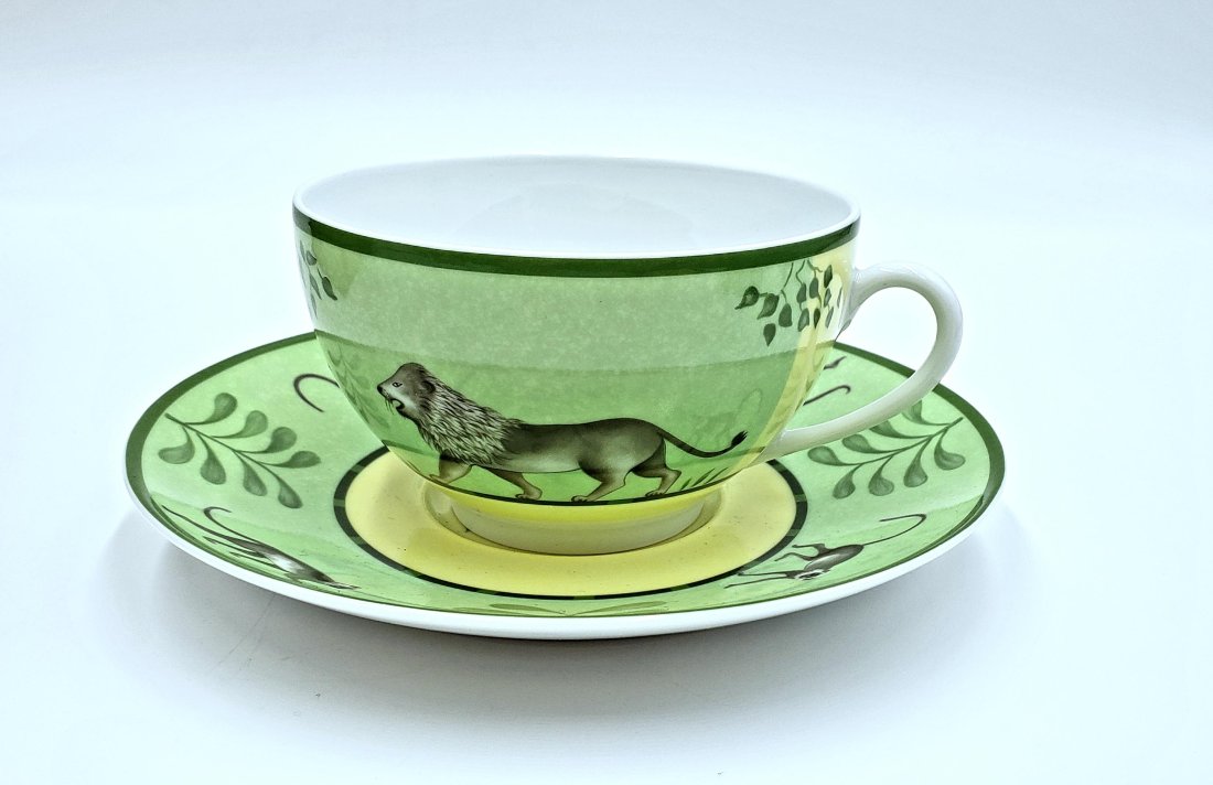 Vintage HermÃ¨s Africa Green Breakfast Cup & Saucer: This charming Hermes porcelain teacup and saucer are from the Africa Green collection featuring the lion on the cup and the elephant centered on the saucer encircled by monkeys on the rim. DIMENSIONS: