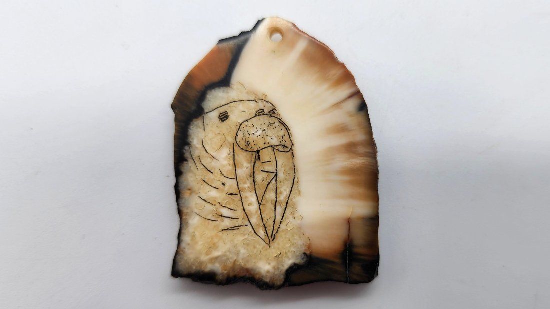 Inuit Fossilized Mammoth Ivory Scrimshaw Pendant of Walrus: Inuit Fossilized Mammoth Ivory Scrimshaw Pendant of Walrus. See photos for details as part of description. Excellent condition. Measures approximately 1.14 inches long x 1.51 inches wide x 0.20 inches