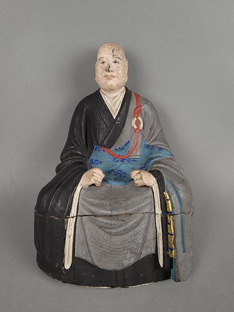 18th C Japanese Carved Wood Abbot Figurine: The hand carved wooden temple figurine of a seated Zen Buddhist monk, hand-painted with polychrome detail, Edo period, circa 1700. Original pedestal seat not present, figure cracked and repaired at bo