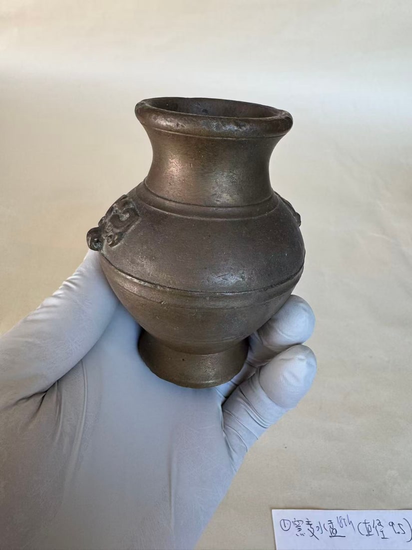A Possibly Han Dynasty Small Vase with Twin Mask Handles: A Possibly Han Dynasty Small Vase with Twin Mask Handles ? size H 3 1/2 in