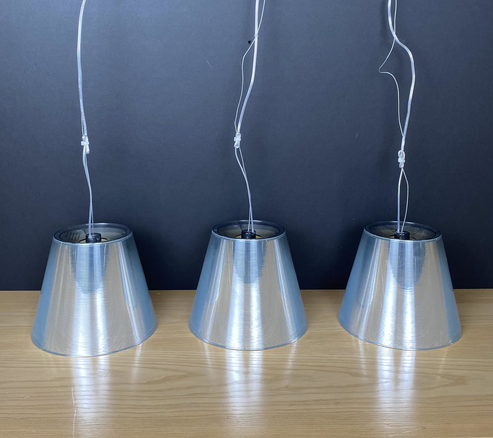 3 Kartell Silver Acrylic Ceiling Pendants: Tapered Cylinders with a length of 7 3/4", Top Diameter is 5 1/2", bottom diameter is 9 1/4". These Kartell Clear Acrylic with silver Interior ceiling pendants are chic in any room.