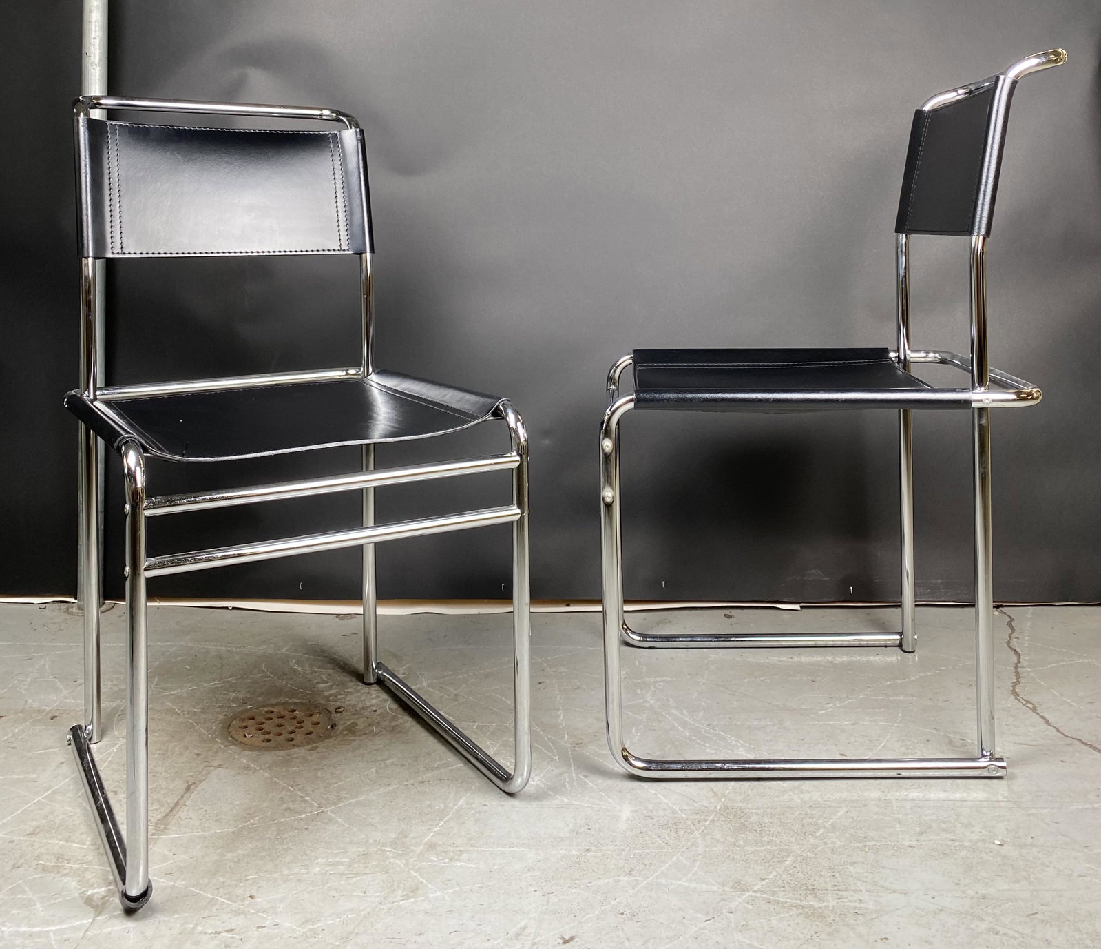 Pair of Black Leather Sling almost Cantilever Chairs: In the style of Mies Van Der Rohe, this pair of black leather sling chairs, are set on chrome, almost cantilever bases. Overall Height is 34" with a seat height of 18".***Pick up for this item is in M