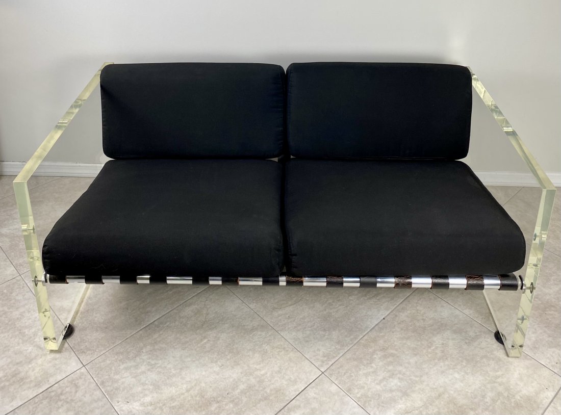 Lucite Loveseat with Aluminum and Leather Straps: BG Galleries Lucite, Aluminum and Leather Strap loveseat. New Upholstered Cushions and back pillows. Upholstered in a black canvas acrylic mix.Length 56 7/8", 32" Depth, 24 1/2" HSeat Height, 11 1/2Ba