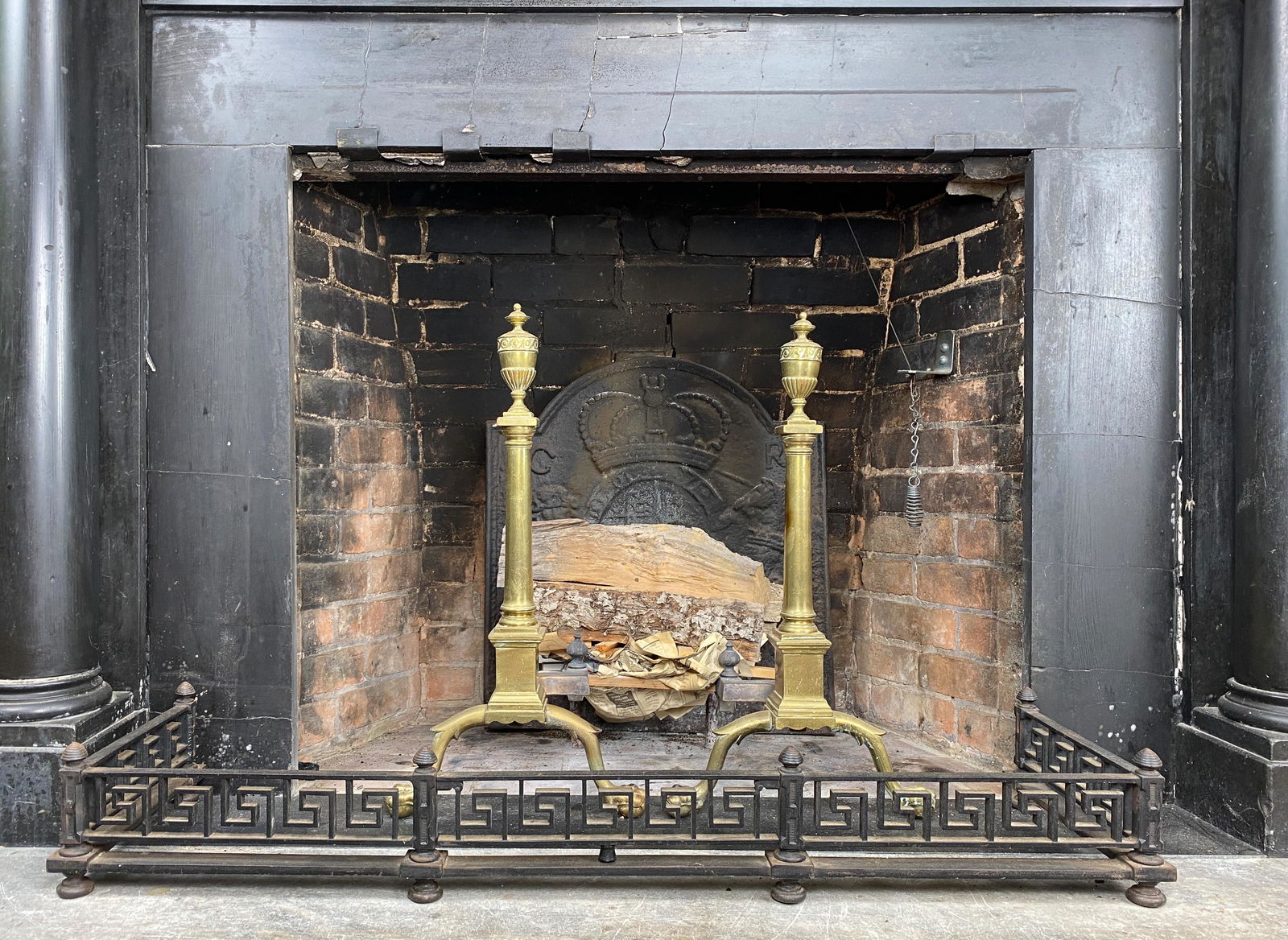 Vintage Pair of Brass Andirons: Beautiful vintage pair of brass fireplace andirons with finial tops. Centered columns resting on squared chased engraved medallion plinth with spur legs and ball and claw feet.