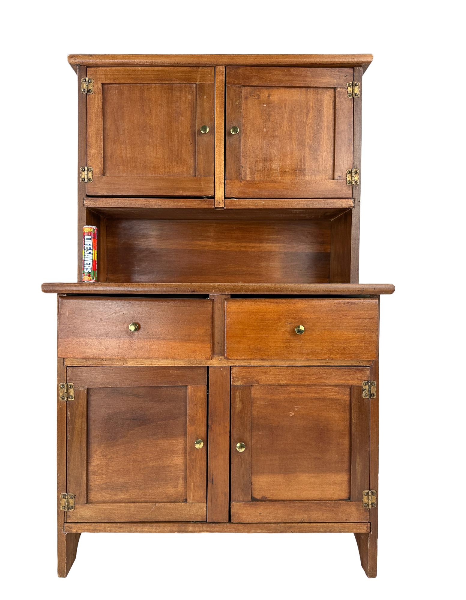 Antique Miniature Hoosier Cabinet: Antique or Old Vintage, four door, two drawer hoosier cabinet with brass hardware. Dimensions Width: 19" Depth: 11" Height: 31 3/4"