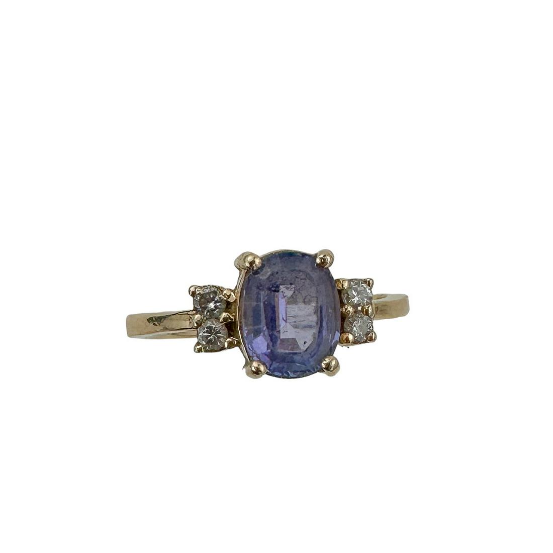 14 Kt Gold Tanzanite and Diamond Ring: Purple Tanzanite in a four prong setting flanked by four diamonds. Size 5 1/2 Rare gemstone only sourced in Tanzannia, African Mines.