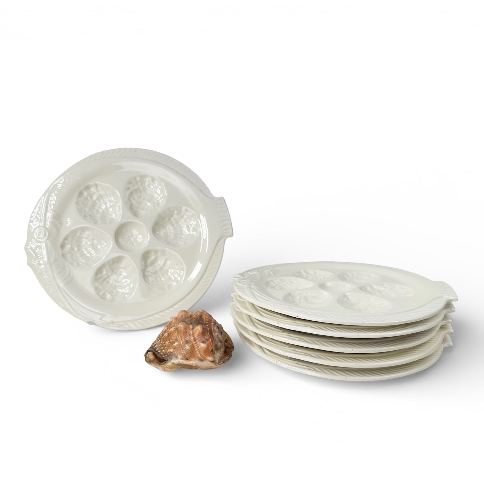 (6) Faiencerie D'Onnaing Nord Barbotine Majolica Oyster Plates: c. 1890, Faiencerie D'Onnaing Nord, French Barbotine Majolica Oyster Plates in White with clear glaze in a fish shape. Each plate contains 6 spots for oyster shells and a center for lemon or vinegar.