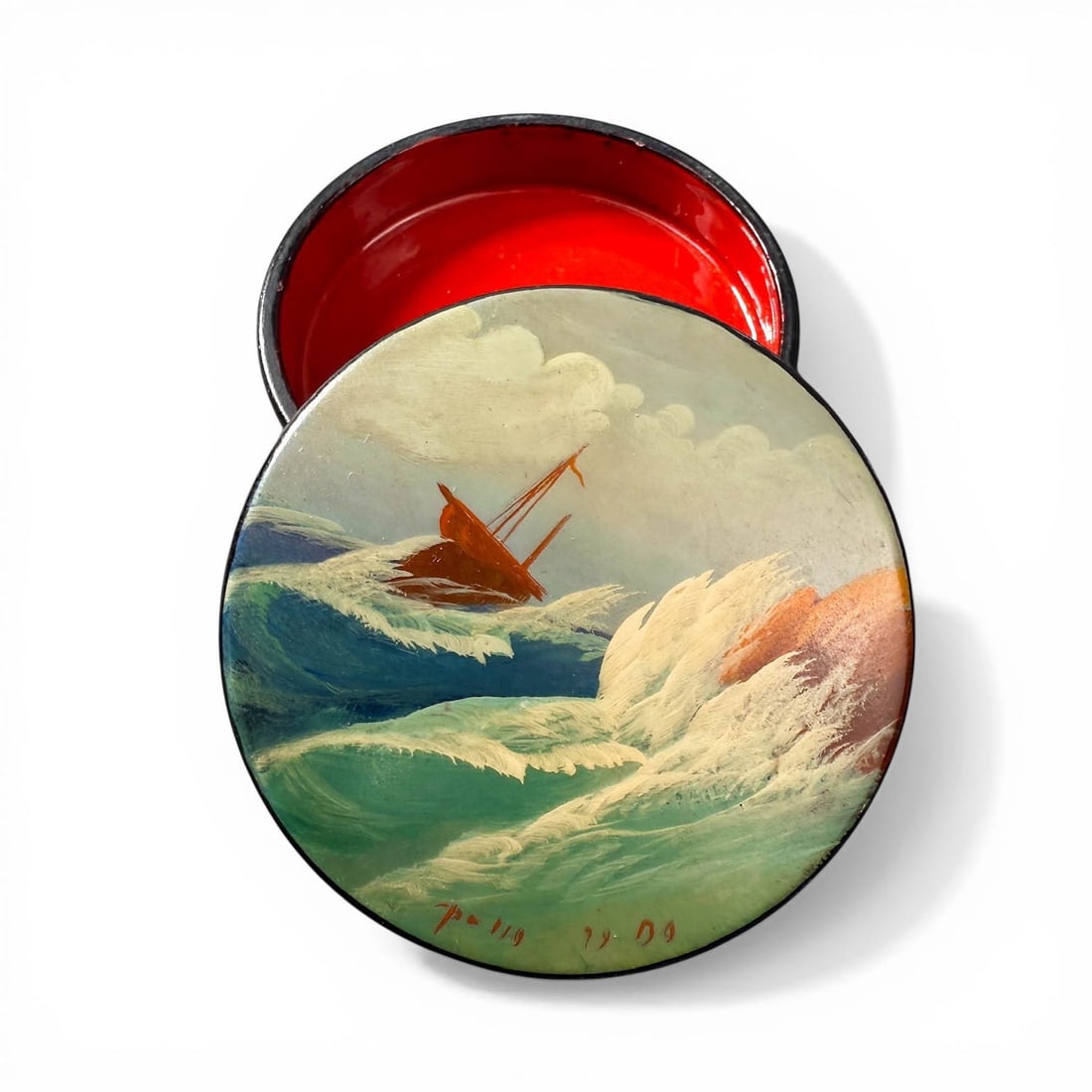Antique Lacquered Snuff Box with Ship in Stormy Seas: Antique c. 1904 Lacquered Snuff Box with painted scene of ship in stormy seas. Signed on bottom, dated 1904 with a Black Exterior, Red interior. Measures 2 1/2" Diameter x 3/4" H Please refer to the f