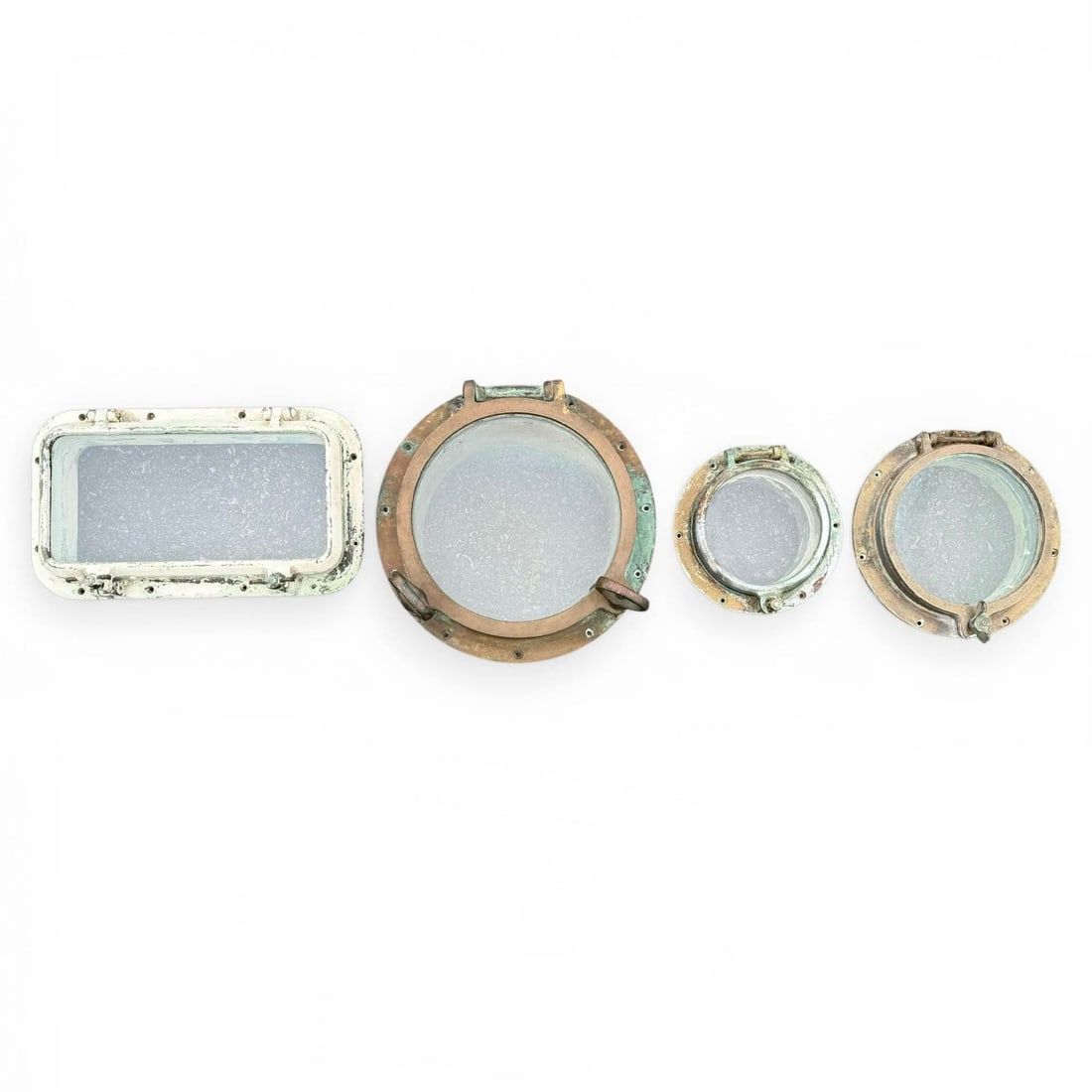 (4) Brass and Metal Ship Portholes: Three Round, one rectangular ship portholes. In brass with their original glass panes. Portholes Measure 9" Diameter with 4" Depth (5" Depth to top of bolt), Glass opening 5 7/8" 11" Dia, 3 1/4" D (4