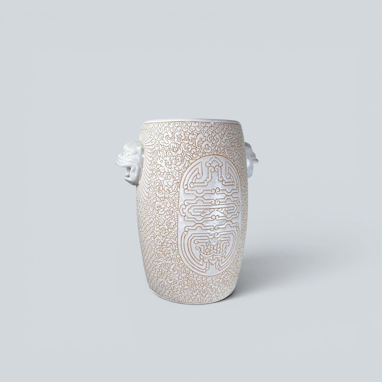 WHITE CERAMIC GARDEN STOOL WITH FOO DOG HANDLES: Chinoiserie style foo dog or lion head handle garden stool in white with intricate pattern in relief in orange.