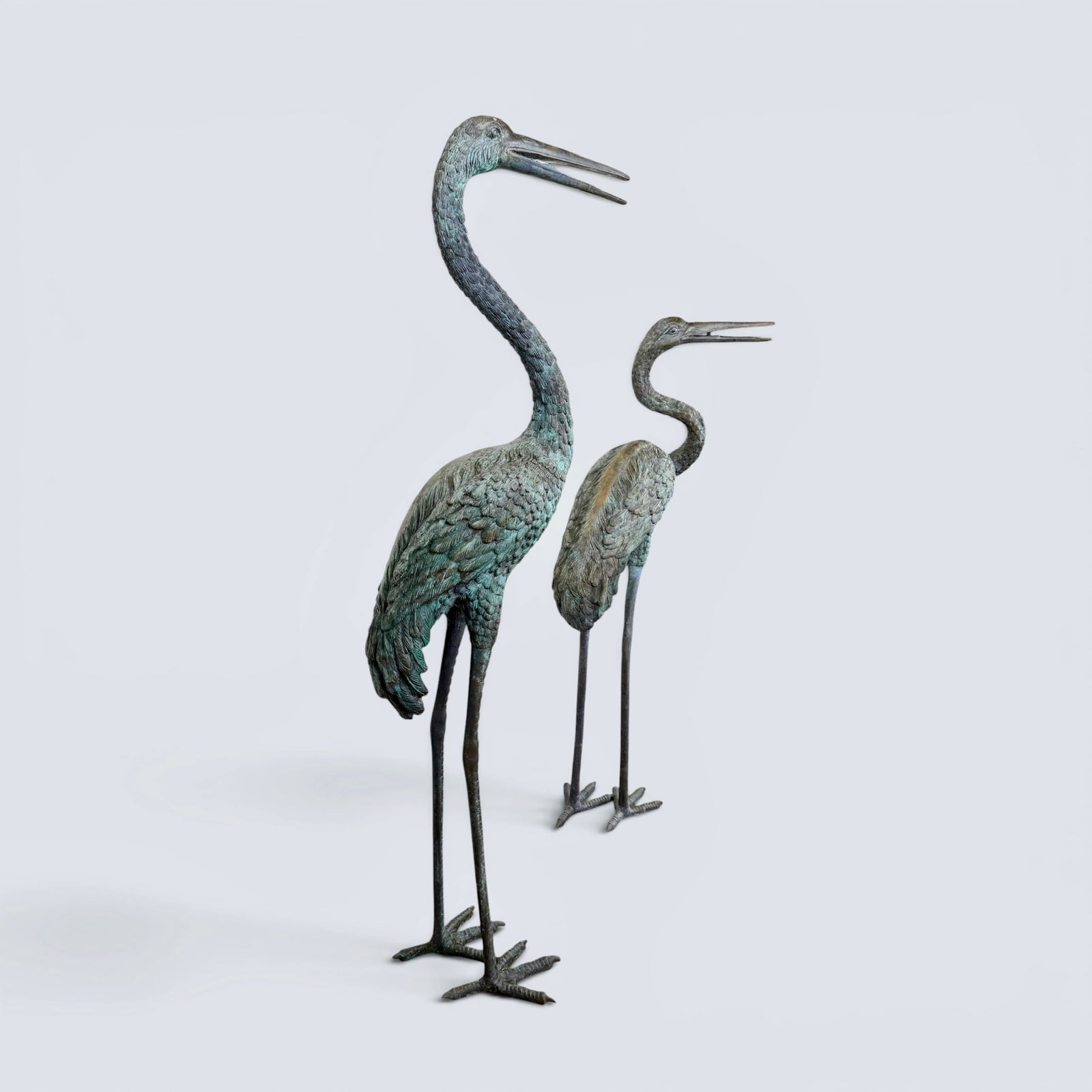 LARGE BRONZE CRANES: Unsigned, patinaed bronze standing cranes stand 53 and 45 inches tall. 53" h h, 17" w, 10" d 45" h, 22" w, 11" d