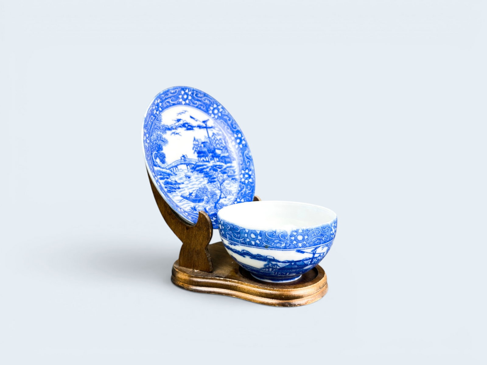 CHINESE EXPORT BLUE AND WHITE TEACUP AND SAUCER: Antique Chinese porcelain saucer and cup. Scene depicting fishermen on bridge and in river. Saucer diameter 5 3/8" tea cup 2" h x 3 3/4" Diameter