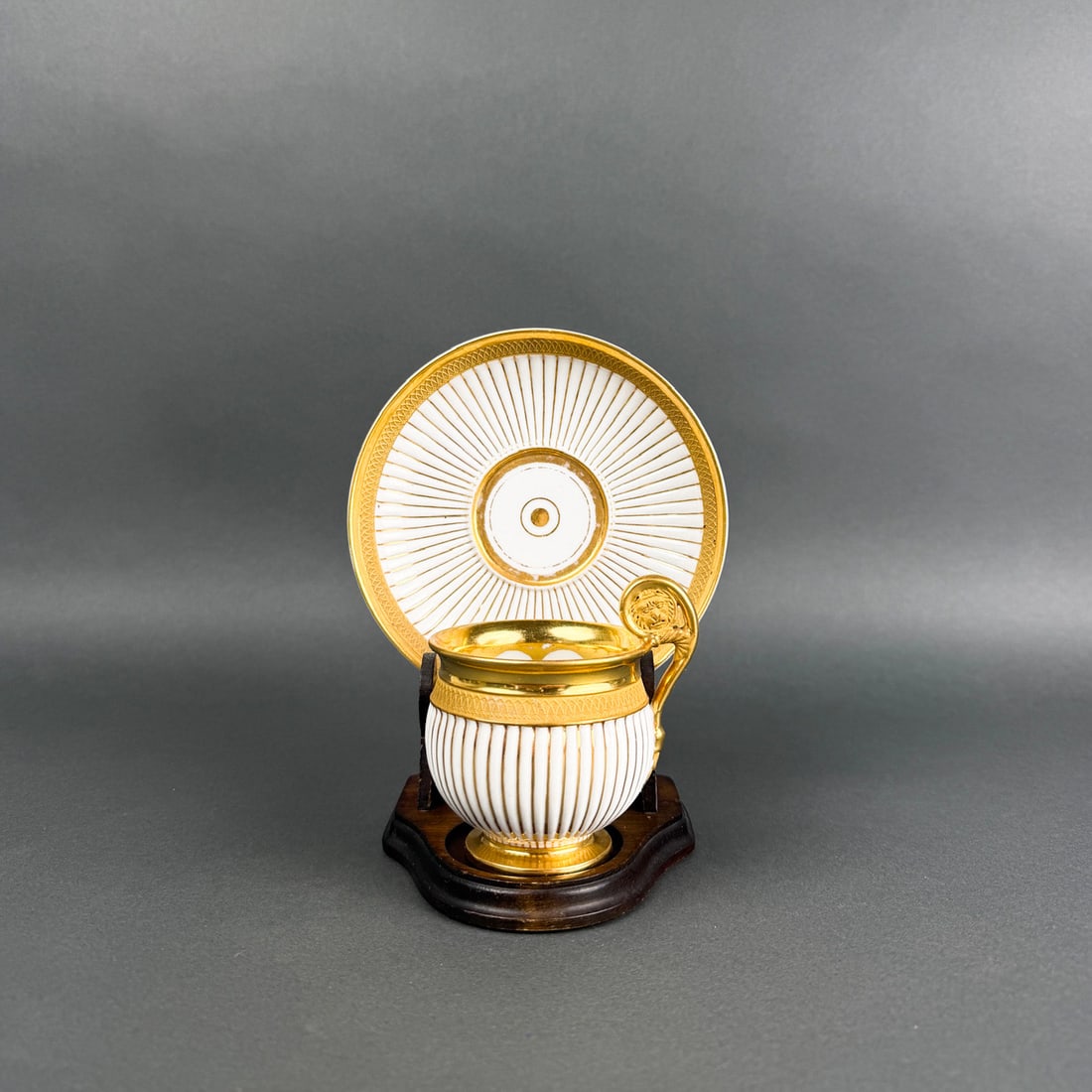 Early 20th c. R.P.M. PORCELAIN AND GILT DEMITASSE AND SAUCER: Antique Reinhold Schlegelmilch R.P.M, Bavaria porcelain demitasse and saucer in neoclassical style. Iconic intricate lion head at handle and fluted sides.