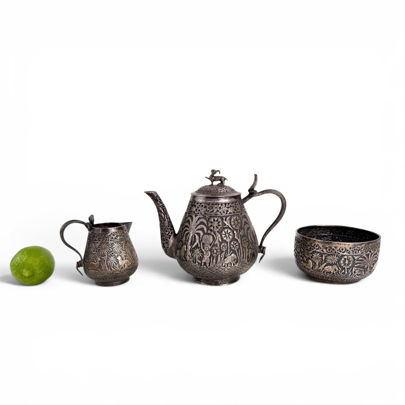 (3) PIECE ANGLO-INDIAN SILVER TEASET: Each hand chased with figures and animals in a jungle setting. Including a Teapot, creamer and sugar 5 inches (and smaller) unmarked.
