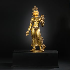 A Chinese gilt bronze statue of a standing Buddha inlaid with turquoise from the Yuan Dynasty