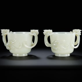 A pair of Hetian white jade cups with double dragon handles from the Qing Dynasty, China