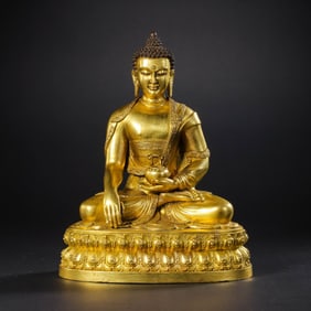 A Chinese Ming Dynasty gilt-bronze statue of seated Sakyamuni Buddha