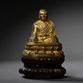 A Chinese Ming Dynasty gilt bronze statue of a seated Buddha