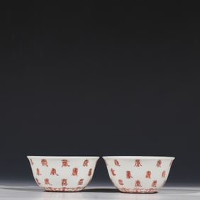 A pair of Chinese Ming Chenghua period alum-red cups with longevity patterns