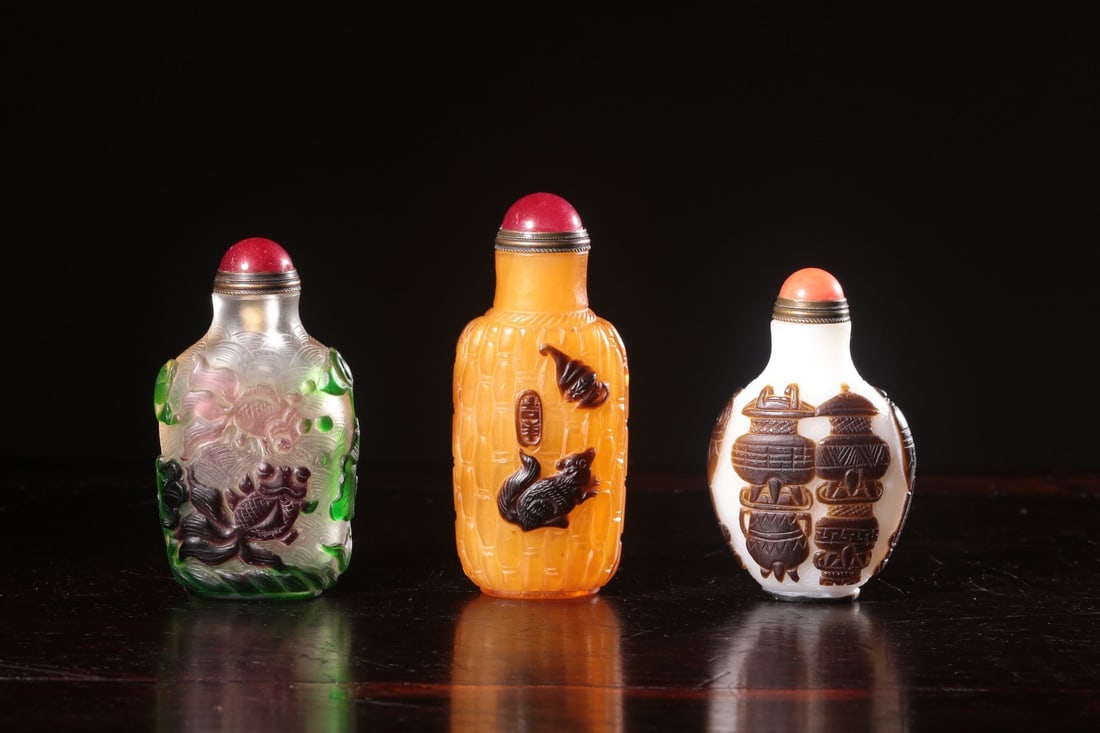 A set of glass snuff bottles bearing the mark "Made in the Qianlong Period" that have returned from: H. 7.8 cm. L. 4.5 cm. W. 2.6 cm. H. 8.8 cm. L. 3.8 cm. W. 2.7 cm. H. 7.3 cm. L. 4.7 cm. W. 2.7 cm.