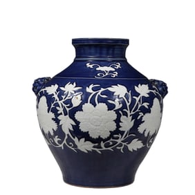 A Yuan Dynasty Chinese celadon-glazed vase with white floral patterns and two animal-head designs.