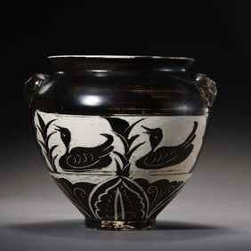 A black and white glazed double-animal-head jar with mandarin ducks playing in water design from the