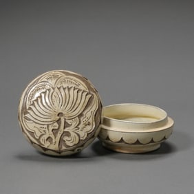 A white-glazed box with carved lotus flower pattern from the Cizhou kiln during the late Tang and