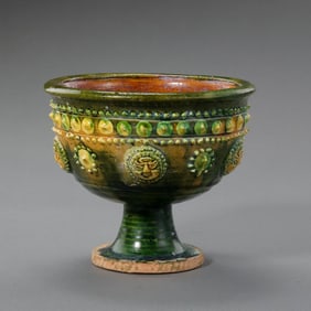 A Chinese Sui Dynasty yellow-green glazed stem cup with applied drum nail patterns.