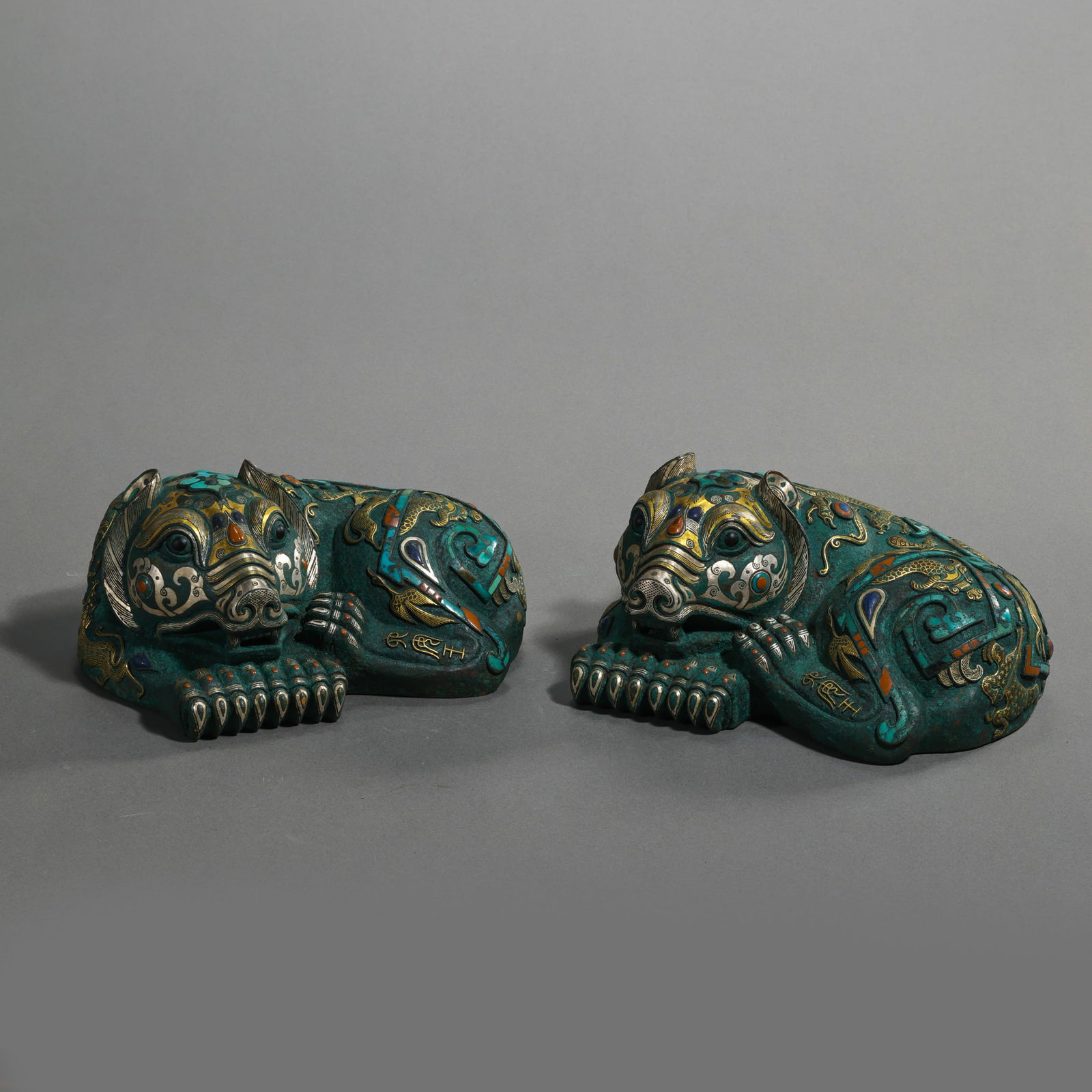 A pair of Chinese Warring States period auspicious beasts inlaid with gold and silver: L. 15.5 cm. H. 7 cm. Weight. 2600 gram.