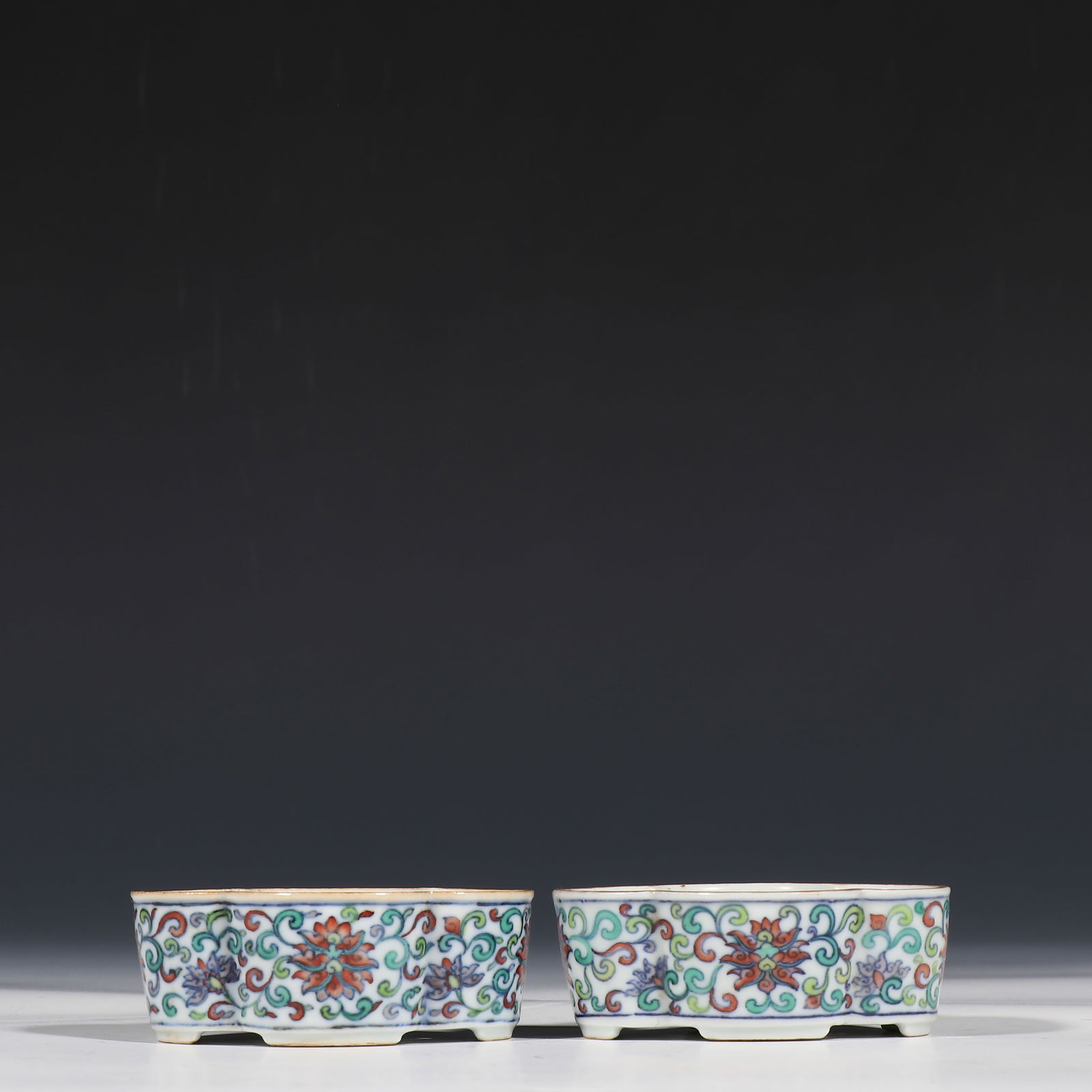 A pair of Chinese doucai floral-patterned begonia-shaped wash basins from the Qianlong period of the: H. 3 cm. L. 16.7 cm.