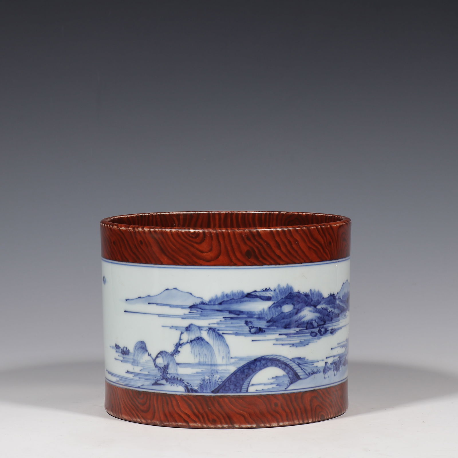 Blue and white porcelain brush pot with landscape and wood pattern from the Yongzheng period of the: H. 14.2 cm. Diam. 18.8 cm.