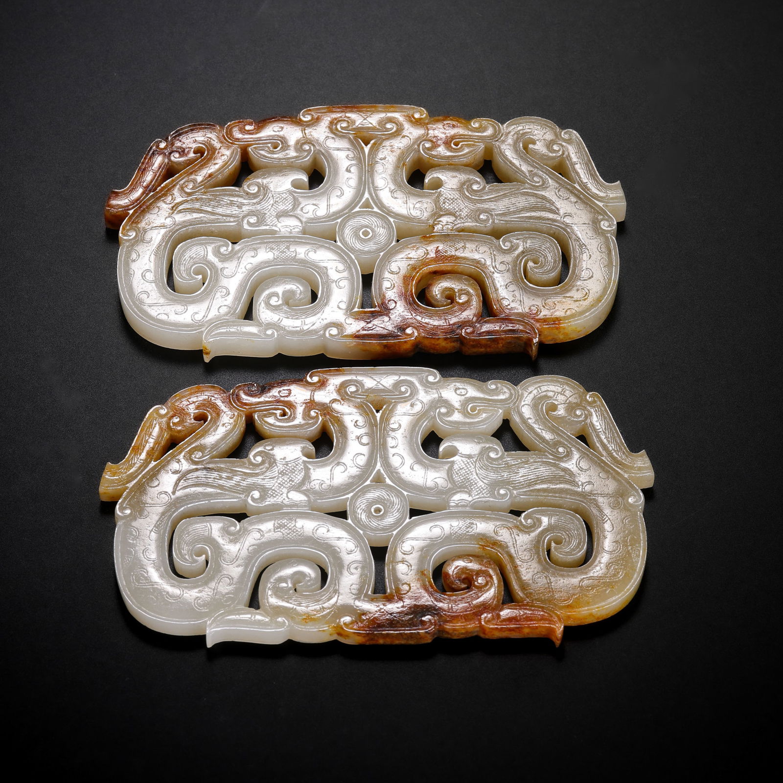 A pair of Chinese Han Dynasty jade pendants with double dragon patterns: L. 9.6 cm. W. 5.5 cm. Weight. 109 gram.