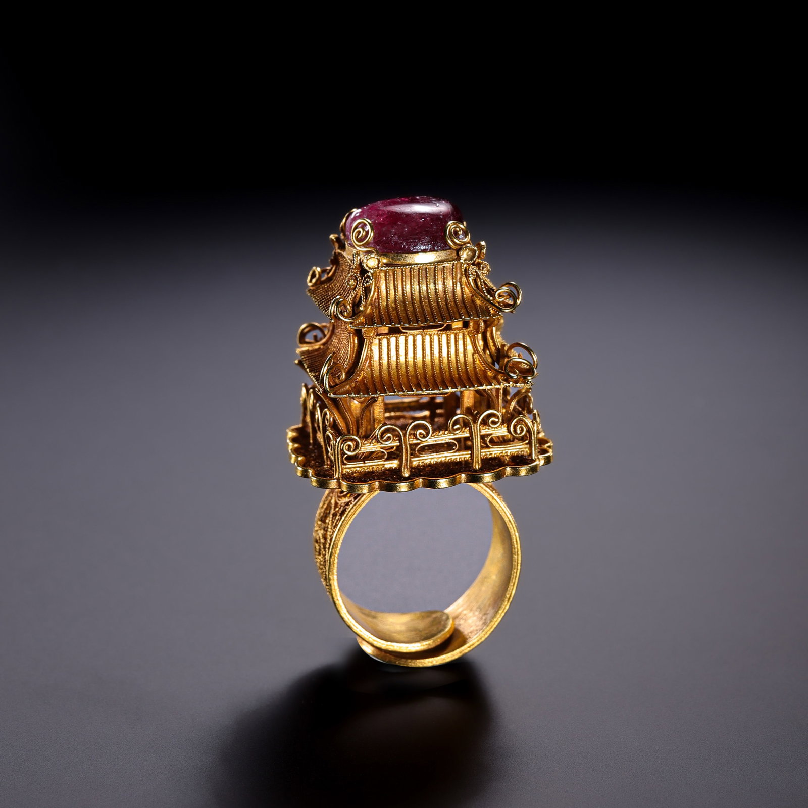 A pure gold pavilion and tower ring from the Qing Dynasty of China, inlaid with gemstones.: H. 5 cm. W. 2.5 cm. Weight. 29 gram.